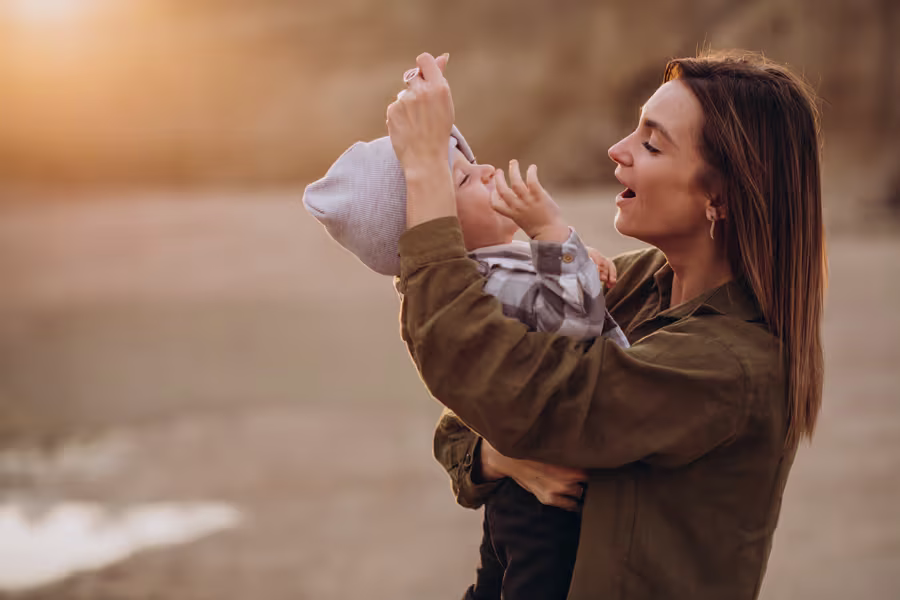 Mamá abrazando a su bebé en la playa